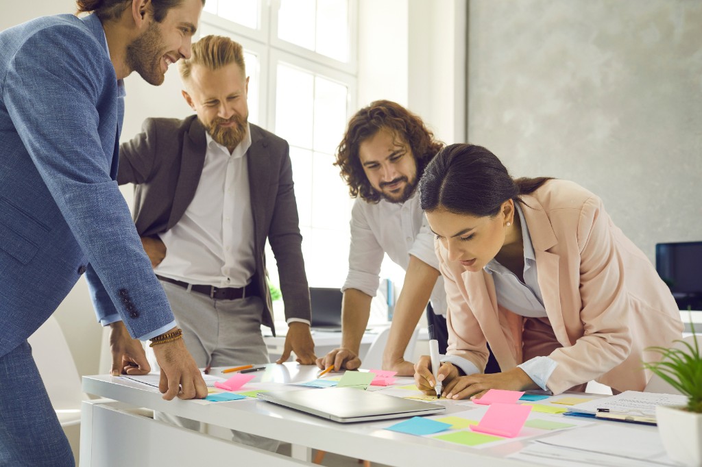 Team collaborating around a table with sticky notes during a planning session